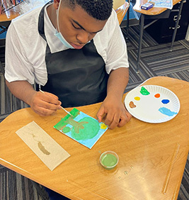 Boy painting a tree