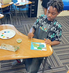 Boy painting a tree